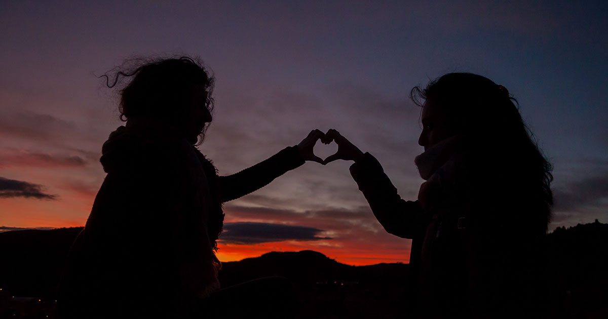 two friends holding hands silhouette